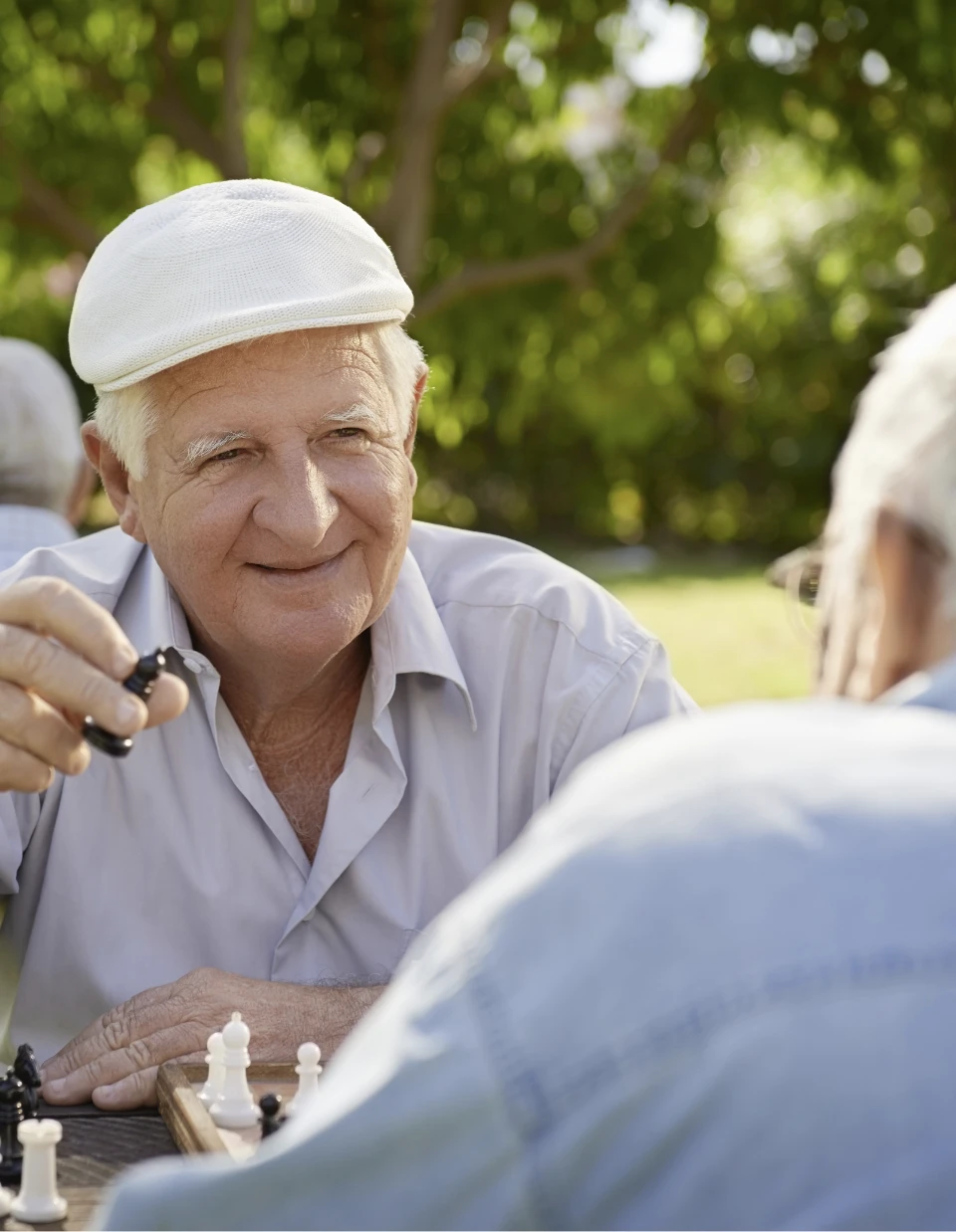 Senior lacht beim Schach spielen